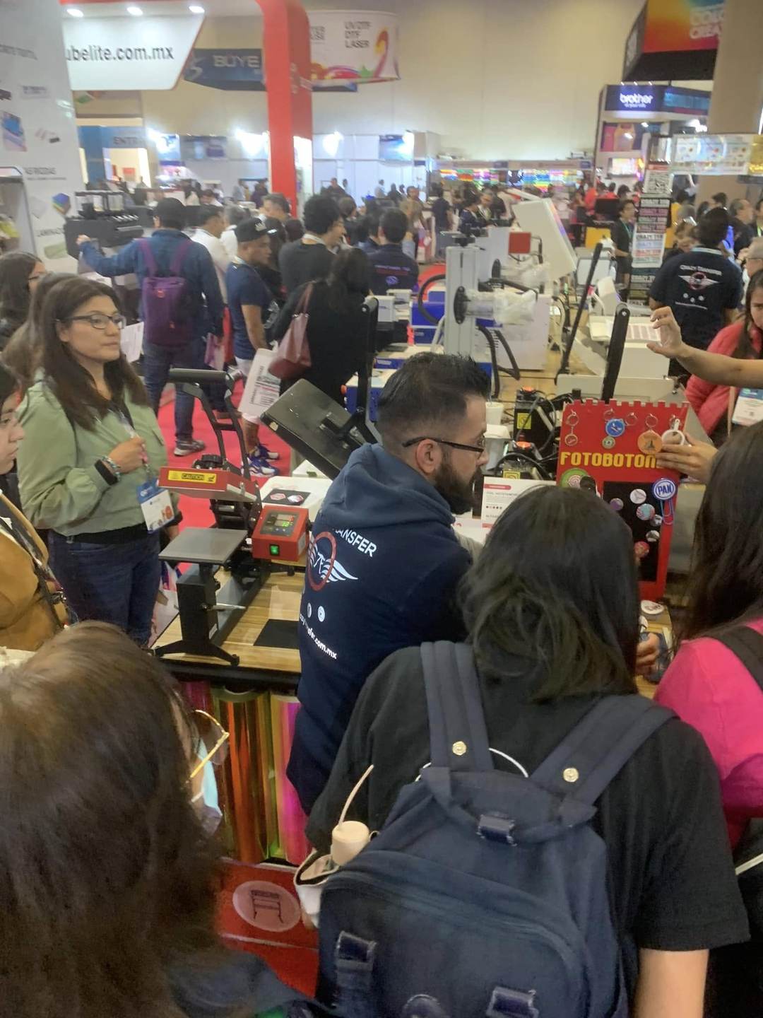Visitantes en un stand de personalización y productos promocionales